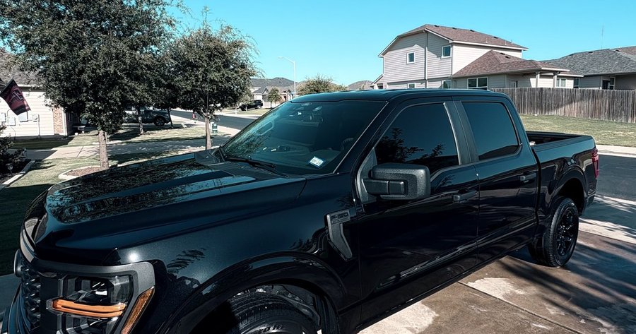 Freshly detailed blacked-out Ford F-150 pickup in a driveway